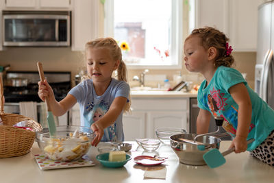 Girl having food in kitchen at home