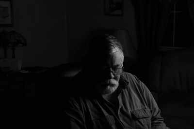 Senior man sitting in dark at home