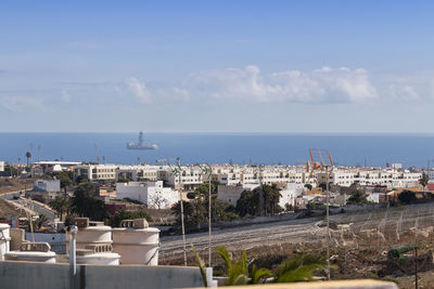 High angle view of buildings by sea against sky