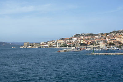 View of townscape by sea against sky