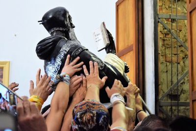 Midsection of woman holding statue in city