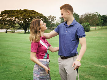 Young couple standing at golf course