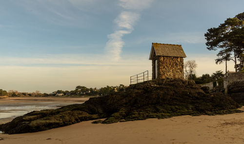 Built structure on beach against sky