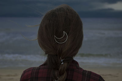 Rear view of woman with moon shape hair clip on hair at beach