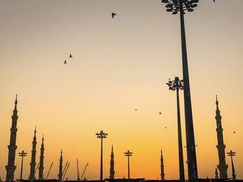 Low angle view of birds flying against sky during sunset