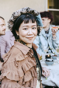 Portrait of smiling transwoman sitting during dinner party in back yard