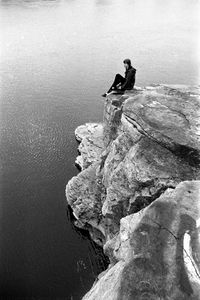 Woman standing on rock formation in sea