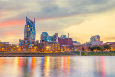 Reflection of buildings in city at sunset