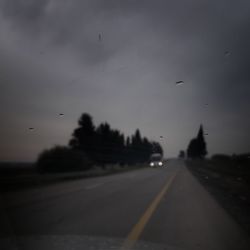 Cars on road against sky during sunset