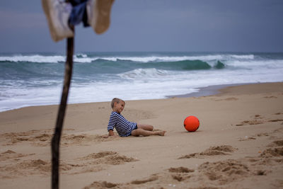 Young soccer player plays barefoot on the ocean shore. football, sport, passion. active lifestyle