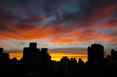 Silhouette buildings against sky during sunset