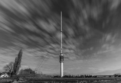 Tower on field against cloudy sky