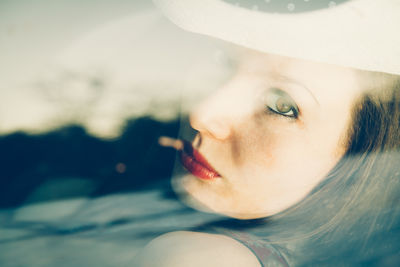 Close-up portrait of young woman wearing hat