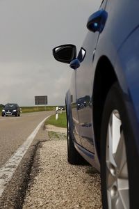 Cars parked on road against sky