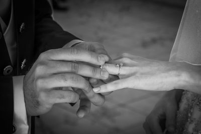 Midsection of bride and groom during wedding ceremony