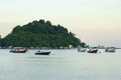 Boats sailing in sea against sky