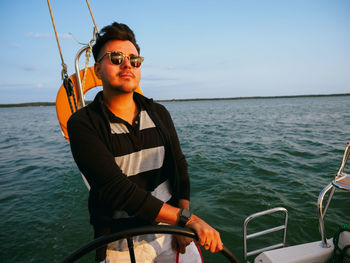 Handsome person steering wheel sailing yacht or sailboat on a vacations person