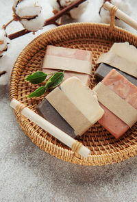 Assorted handmade natural soap bars, massage towel and green leaves. 