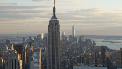 Modern buildings in city against cloudy sky