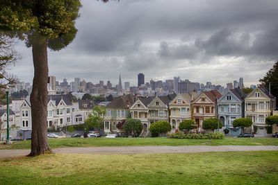 Buildings in city against cloudy sky