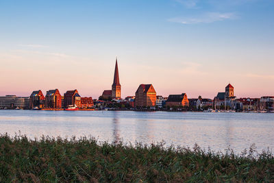 River with buildings in background at sunset