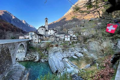 Arch bridge over river against buildings