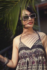 Portrait of woman wearing sunglasses standing outdoors