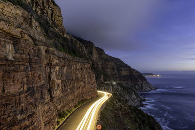 Scenic view of mountain road by the sea