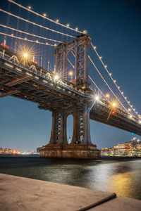 Low angle view of bridge over river at night