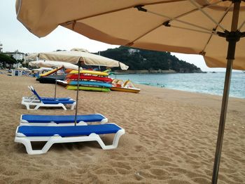 Chairs on beach against sky