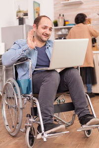 Full length of man sitting on mobile phone