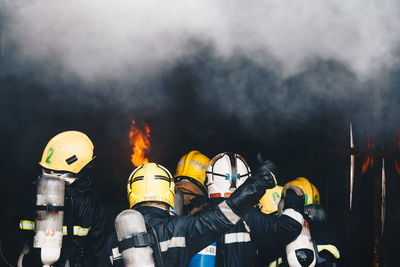 Rear view of firefighters extinguishing fire 