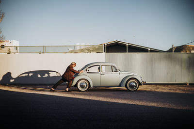 Senior man pushing vintage car