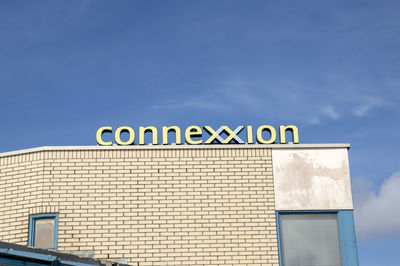 Low angle view of text on building against sky