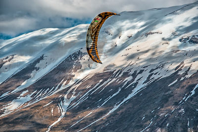 Aerial view of snow covered mountains against sky