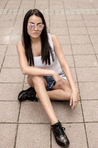 Young woman sitting on walkway