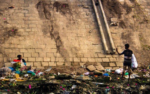 Rear view of men standing against wall