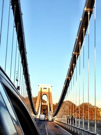 Low angle view of suspension bridge against sky