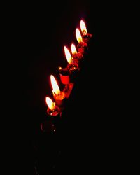 Close-up of lit candle in darkroom