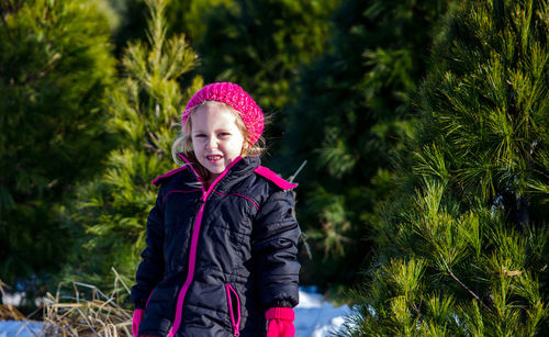 Child on a christmas tree farm in winter looking for the perfect tree