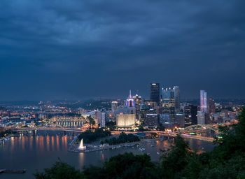 Illuminated buildings in city at dusk