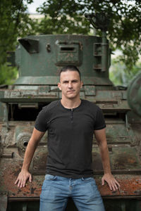 Portrait of man standing against metal structure