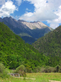 Scenic view of green landscape and mountains against sky