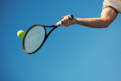 Low section of man holding tennis