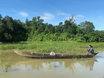 A tribal girl, riding a boat to school, at kaptai lake, rangamati, bangladesh