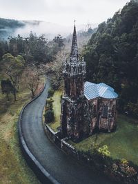 Church by road against trees