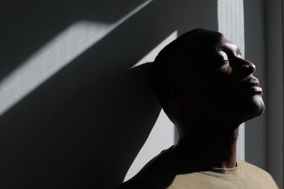 Close-up portrait of young man against wall