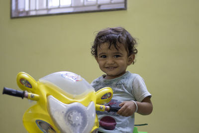 A child sitting on his toy showing a feeling of happiness