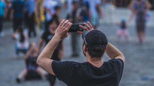 Man photographing with mobile phone on street