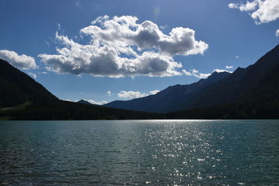 Scenic view of lake by mountains against sky